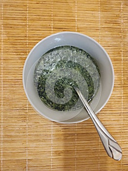 Mladý zelený ječmen nebo chlorella zelené jídlo v šálku nebo misce.
