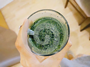 Mladý zelený jačmeň alebo chlorella zelené jedlo v pohári alebo miske.