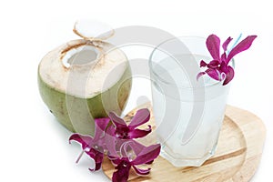 Young green coconut with drinking straw and orchid