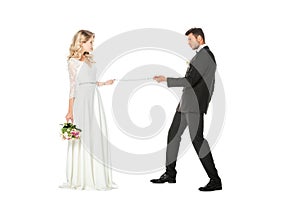 young groom with chain and leashed bride looking at each other