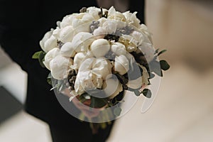 Young groon in his wedding day take a bouquet of flower for his bride photo