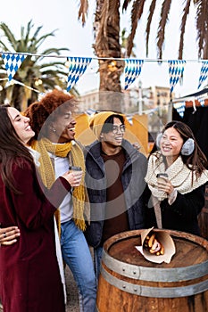 Young group of diverse people in winter clothes having fun on christmas vacation