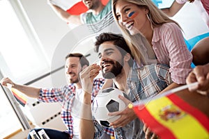 Young group of friends watching sport on television