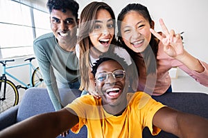 Young group of happy friends having fun at home taking selfie portrait