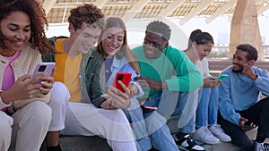 Young group of multiracial friends having fun using mobile phones