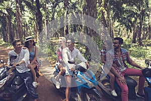 Young Group Of People Driving Scooters Travel In Tropical Forest Cheerful Friends Having Road Trip On Bikes