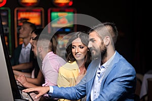 Young Group Playing Automat Machine in a Casino