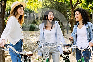 Young group of women with rental bikes hanging out at city street