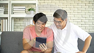 Young grown son teaching Father Use tablet online social media At Home