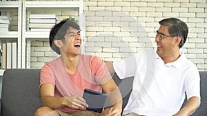 Young grown son teaching Father Use tablet online social media At Home