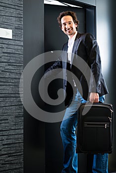 Young guest with luggage entering hotel room