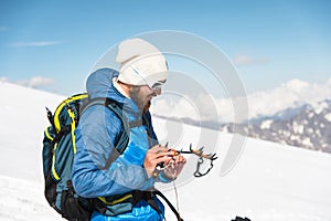 A young guide prepares crampons for use