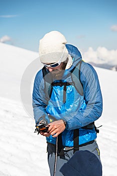 A young guide prepares crampons for use