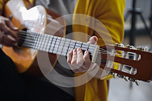 Young guitarist performing melody on musical instrument