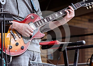 Young guitarist performing on outdoor stage during live concert