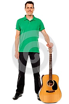 Young guitarist standing with guitar