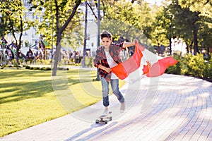 A young guy of 9 years old riding on a sunny road in the evening in the city park, dressed in a flannel plaid shirt. Holding