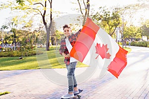 A young guy of 9 years old riding on a sunny road in the evening in the city park, dressed in a flannel plaid shirt. Holding