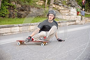 A young guy action makes a slide on a longboard in the resort area of the city