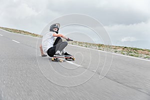 A young guy action makes a slide on a longboard in the resort area of the city