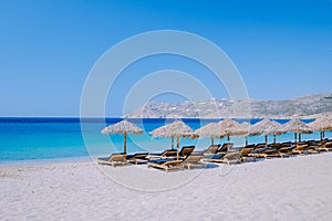 young guy on the beach of Mykonos, Elia beach Mikonos, Mykonos beach during summer with umbrella and luxury beach chairs