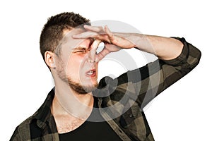 Young guy with beard close nose from a bad smell. Isolated on white background