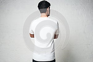 Young guy in blank white t-shirt, back side, horizontal studio p