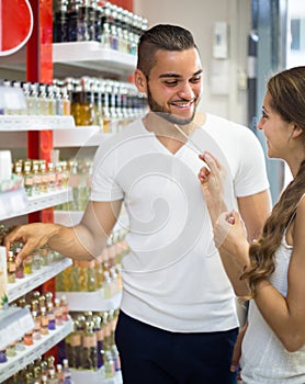 Young guy choosing perfume in the shop