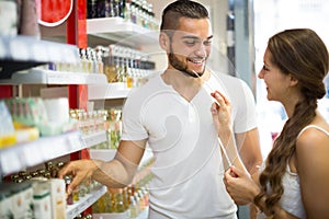 Young guy choosing perfume in the shop