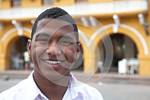 Young guy in a colonial town laughing at camera