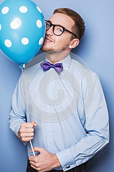 Young guy with a colorful balloon in his hand. Party, birthday, Valentine