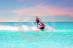 Young guy cruising on the caribbean sea on a jet ski