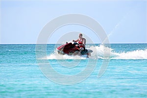 Young guy cruising on a jet ski on the caribbean sea