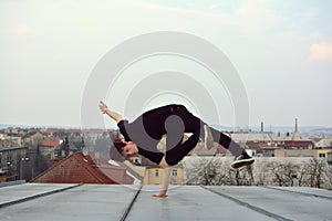 Young guy dancing break dance on the roof