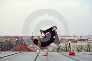 Young guy dancing break dance on the roof