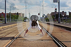 Young guy dancing breakdance on tramlines in the city