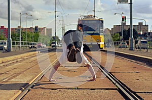 Young guy dancing breakdance on tramlines in the city