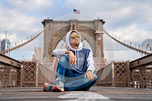 Young guy enjoying empty Brooklyn Bridge with a magical Manhattan island view