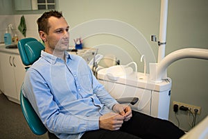 The young guy feels the fear of the dentist. Patient in the Dental Office.