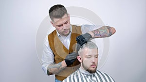 A young guy gets a haircut with hair scissors with a comb.