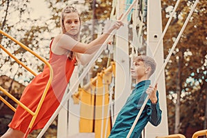 Young guy with a girl on a swing in the park