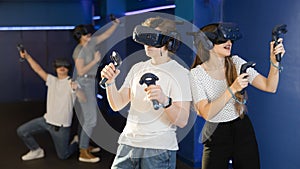 Young guy and girl in vr headset stand shoulder to shoulder interacting with digital interface