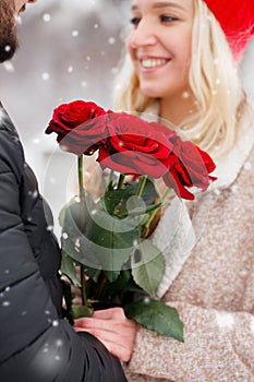 Young guy giving a girl a bouquet of roses, close-up