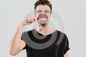 Young guy having fun with magnifying glass