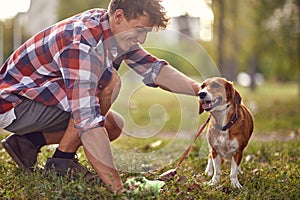 A young guy is having a good time with his dog in the park. Friendship, walk, pets