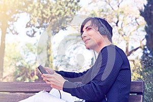 Young guy in headphones listening to music in the street