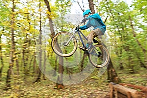 A young guy in a helmet flies landed on a bicycle after jumping from a kicker