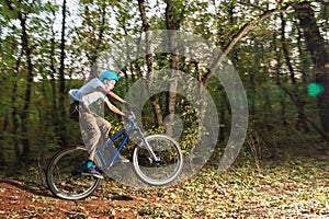 A young guy in a helmet flies landed on a bicycle after jumping from a kicker