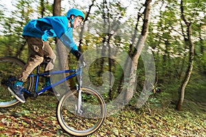 A young guy in a helmet flies landed on a bicycle after jumping from a kicker