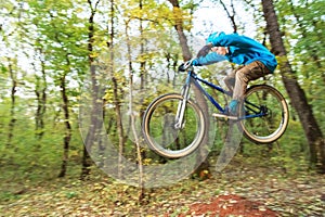 A young guy in a helmet flies landed on a bicycle after jumping from a kicker